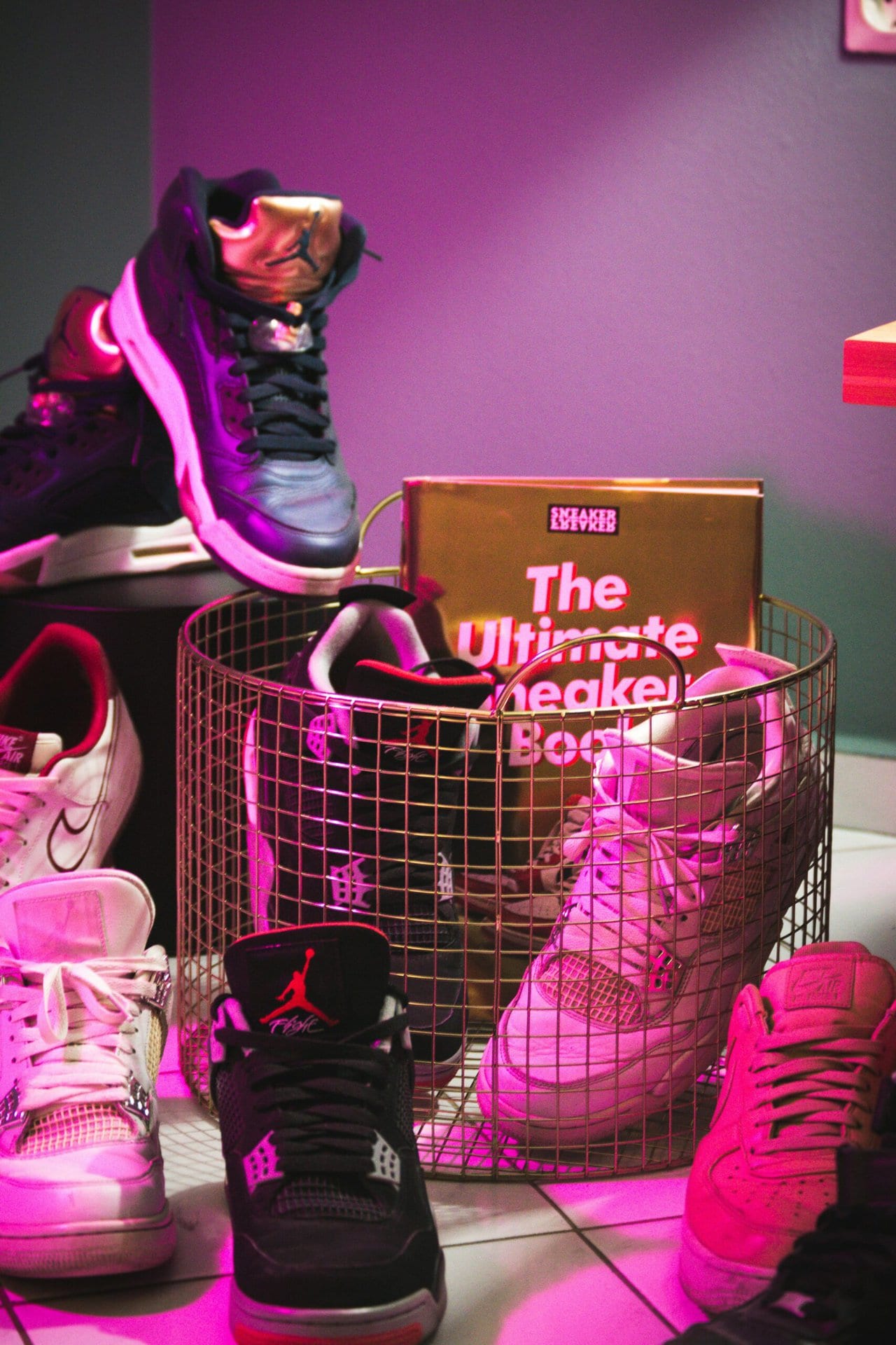 unterschiedliche Sneaker verteilt auf Boden und in einem Korb