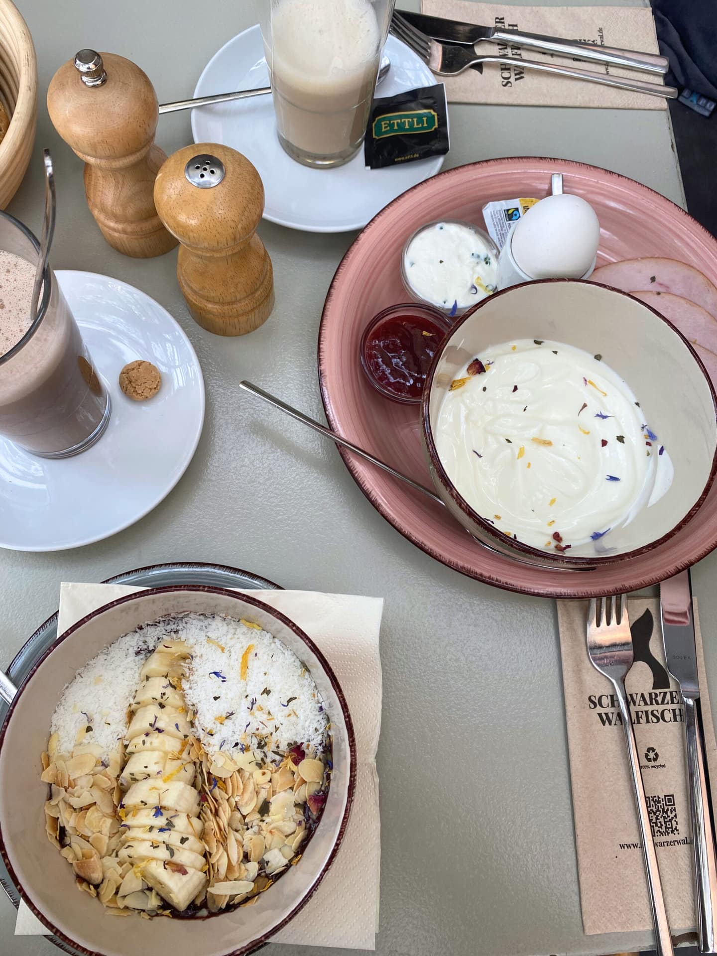 Gedeckter Tisch mit Jogurt-Schüsseln und Gläsern.