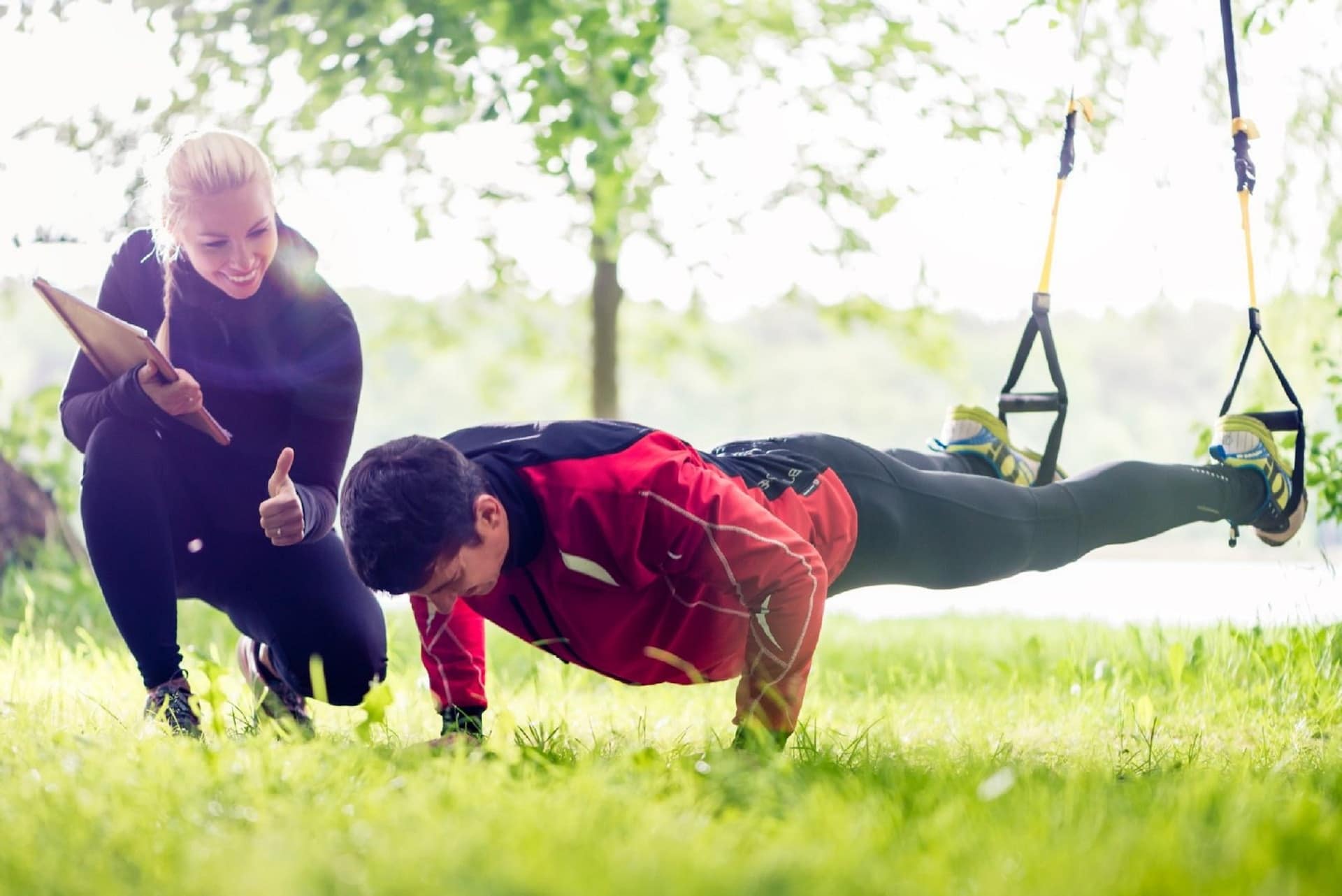 Mann macht Liegestützen während Personal Training im Freien