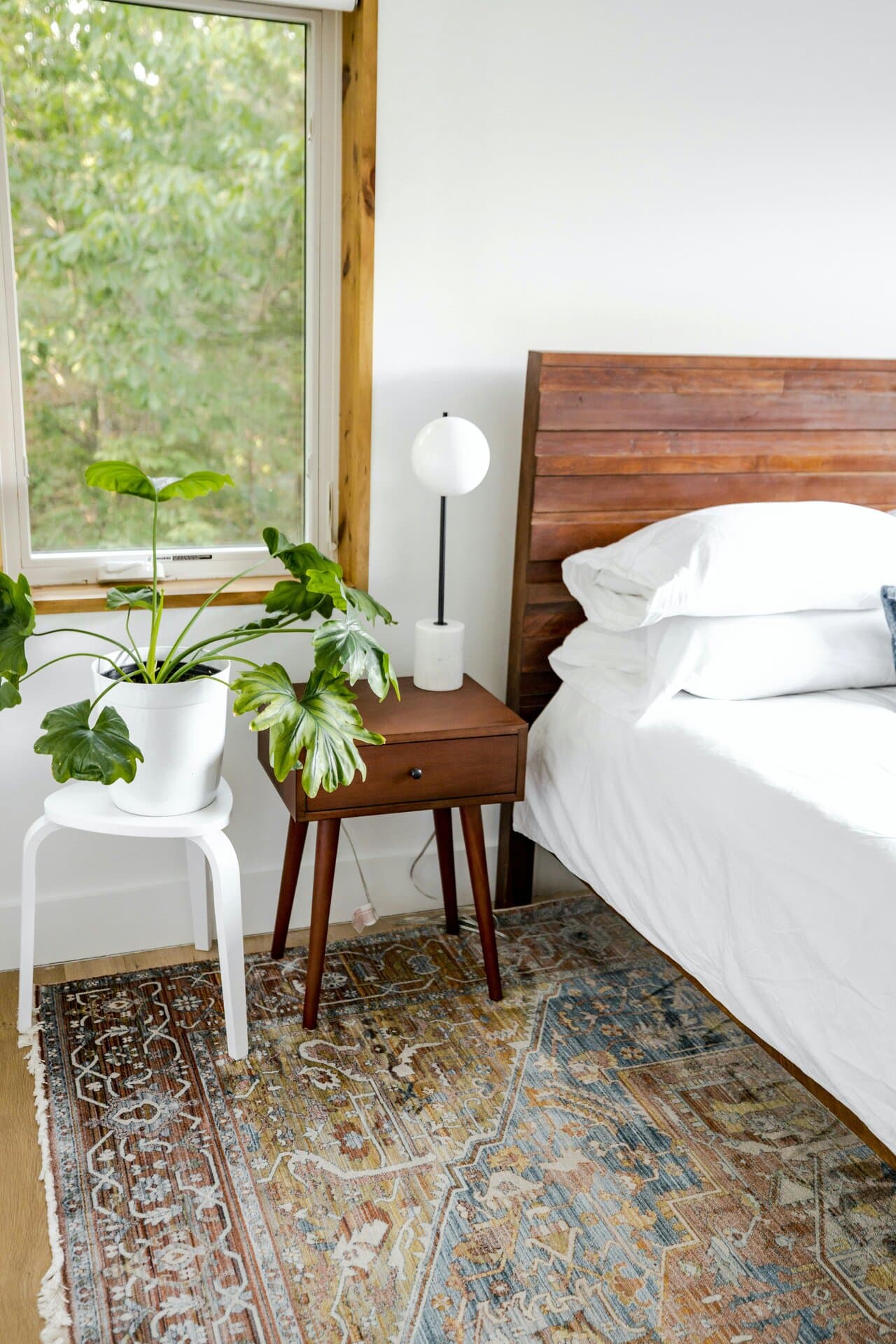 Schlafzimmer mit gemustertem Orientteppich neben dem Bett