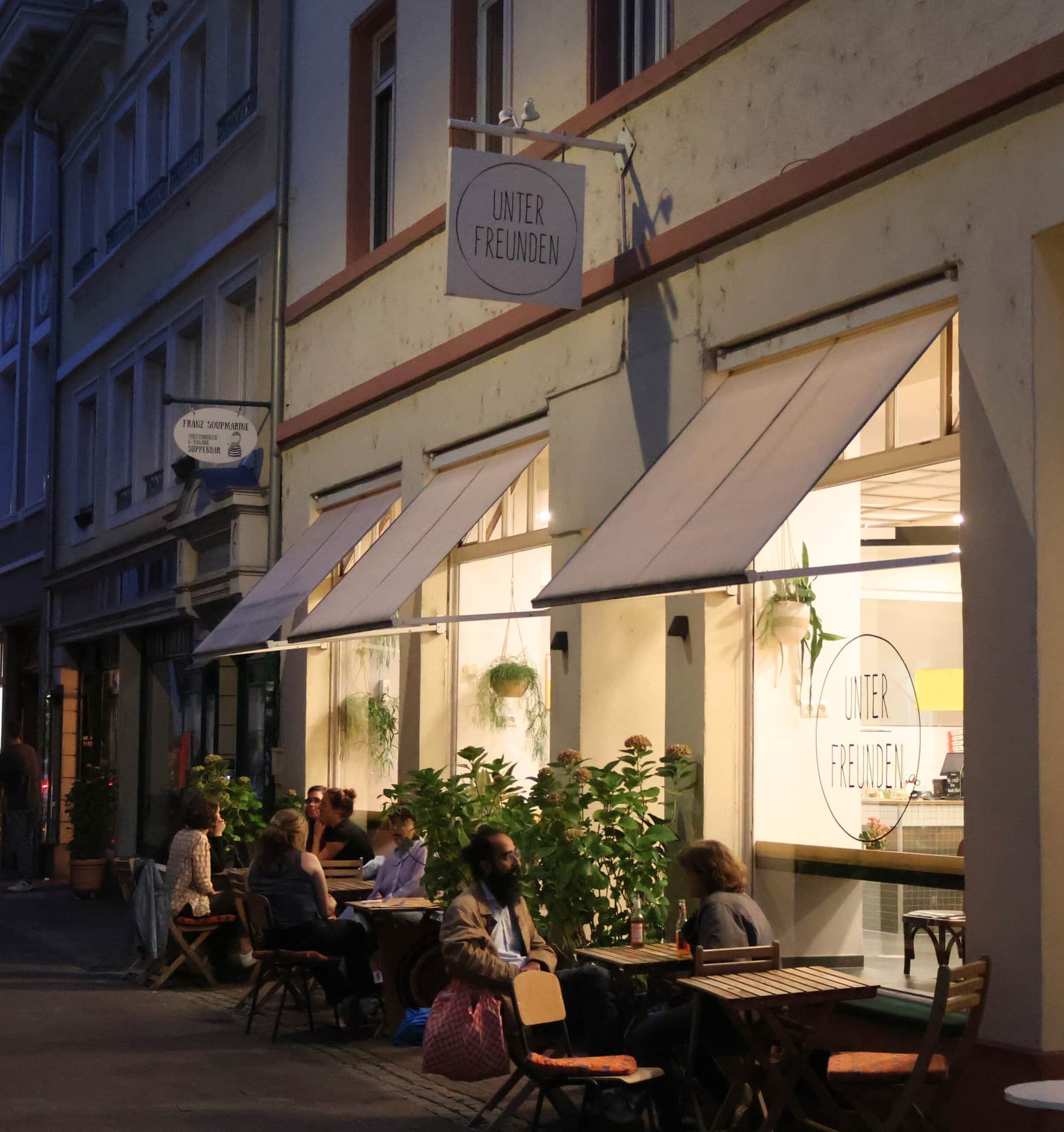 Restaurant Among Friends from the outside in the dark with lights