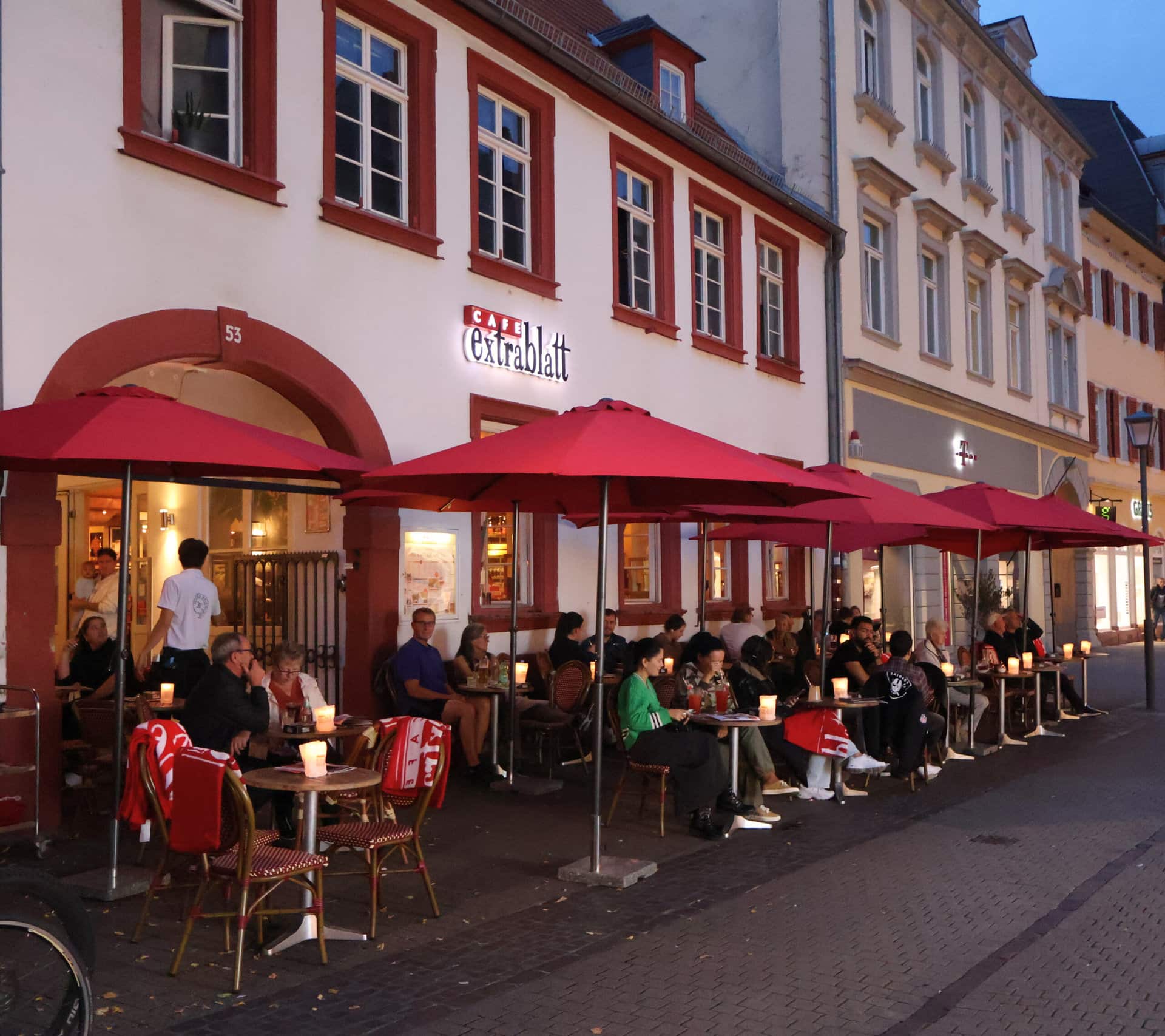 Restaurant mit Bistro Tischen und Stühlen außen im Dunkeln